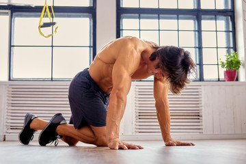 Obraz premium A man doing workouts on a floor in a room.