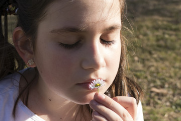 Little girl with flower during the early spring day