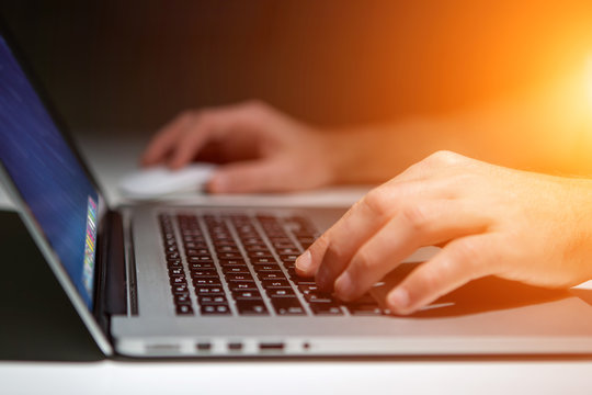 Hand Typing On A Keyboard Of Laptop With Operating System Screen On Background