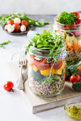 Glass jar with quinoa and vegetables salad. Healthy food, diet, detox, clean eating and vegetarian concept.