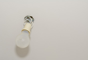 Glühbirne an der Decke installiert mit sichtbaren Elektrokabel 