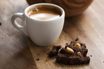 cup of fresh espresso with homemade chocolate cookie with hazelnuts, shallow focus