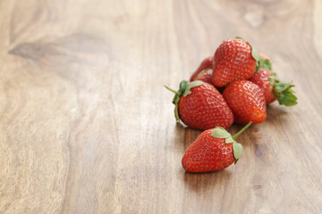 fresh strawberries on old wooden background with copy space, organic berries