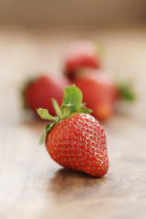 fresh strawberries on old wooden background vertical, organic berries