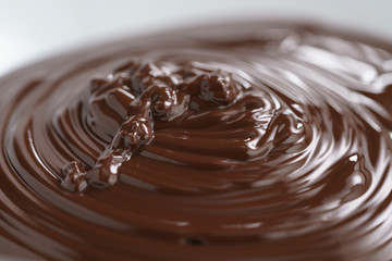 premium dark chocolate poured in bowl, shallow focus