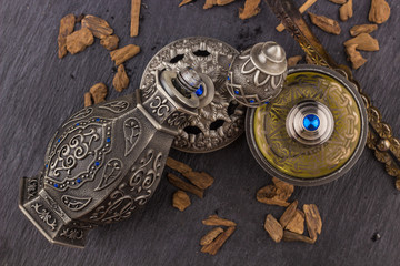 Silver Oriental Artisitc Arabian Oud Perfume / Arabian Oud Perfume with Oud Scented Wood burned in the background with Scented Smoke in the Air 