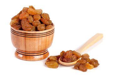 raisins in a wooden bowl with spoon isolated on white background
