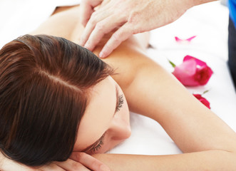 Obraz na płótnie Canvas Beautiful woman receiving a relaxing back massage at spa.