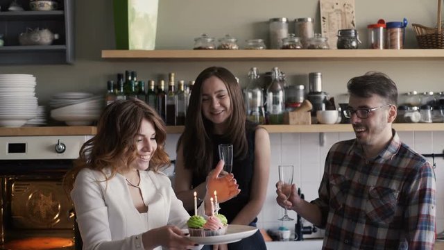 Birthday party, woman blows out the candles on cupcakes