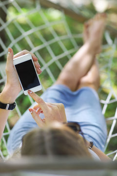 Woman In A Hammock With Mobile Phone On A Summer Day