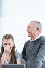 Young woman and senior man laughing