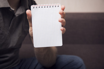 A man is holding a notebook in his hand 