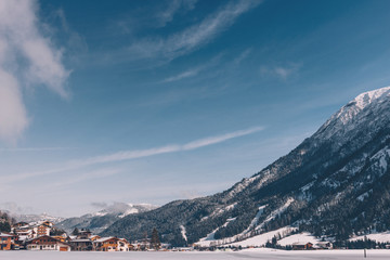 Fototapeta na wymiar Alpine ski resort in a snowy valley with lake