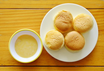 fresh butter cupcake on dish dipping with sweet vanilla sauce
