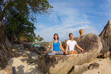 Young couple doing yoga exercises