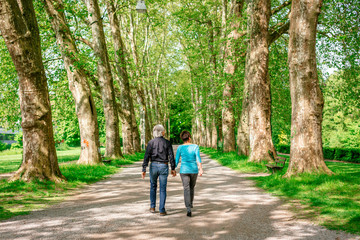 Fototapeta na wymiar Senior Couple Walking Through A Park