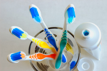 New colorful toothbrushes on a green background. The concept of oral hygiene.