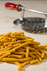 Closeup of Passatelli original Italian pasta over a wooden background