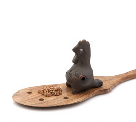 Clay whistle on a wooden spoon with buckwheat groats