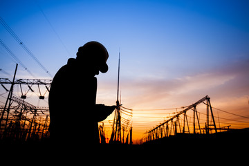 Electricity workers and pylon silhouette
