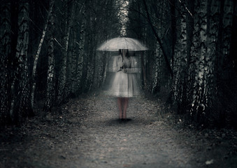 Ghost woman stands on a dark path in the forest - obrazy, fototapety, plakaty