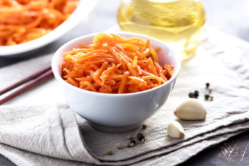 Asian korean carrot salad with spices and garlic in the wooden bowl horizontal