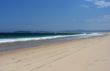 Belmont Nine Miles beach on a sunny day in summertime. Blacksmith Point in the background (Central Coast, NSW, Australia).