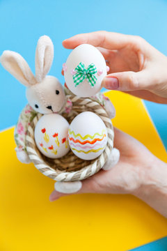 Hands holding basket with Easter eggs