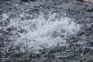Fototapeta na wymiar splashes of water from a fountain on gray background