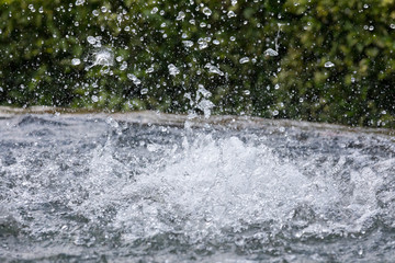 splashes of water from a fountain on green background