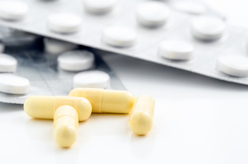 Yellow Capsules with BlisterPacks in Background