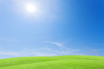 Fototapeta na wymiar Green grass field and beautiful blue sky with clouds background.