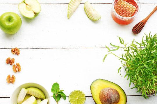 Ingredients For Making Healthy Green Smoothie Or Juice Over White Wooden Table (avocado, Apple, Guava, Honey, Walnut, Sprouts). Detox, Healthy Eating Concept. Copy Space, Top View.