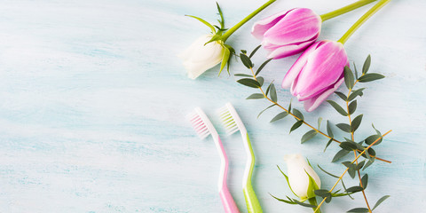 Two pastel toothbrushes with flowers herbs over green textured background. Spring colors. Personal dental health care. Healthy couple concept - 141239369