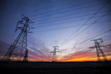 The silhouette of the evening electricity transmission pylon