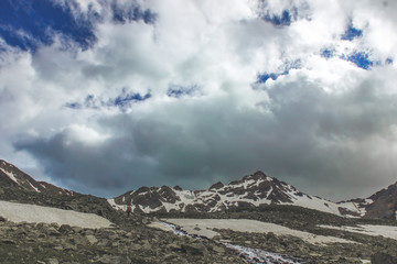 Fototapeta premium Gloomy sky. A lonely tourist goes up the hill along the river