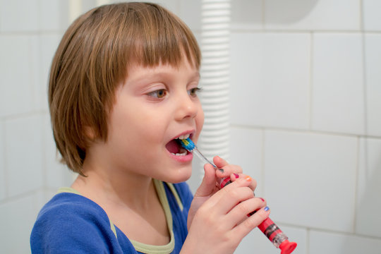 Kid girl brushing teeth in bathroom