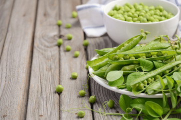 Fresh green peas on rustic wooden background, selective focus. copy space