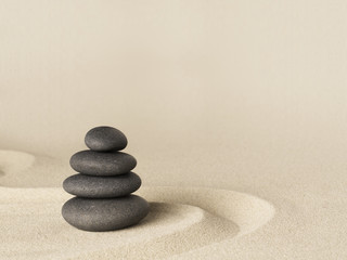 Balance and harmony, zen stone garden background. Dark black stones on fine sand standing for...