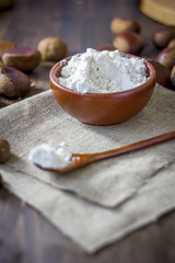 Natural organic chestnut flour in brown ceramic bowl.