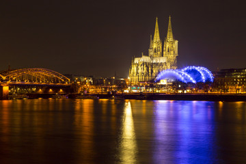 Cologne Cathedral (German: Kolner Dom, officially Hohe Domkirche St. Peter und Maria) and Hohenzollern Bridge across the Rhine, Germany, at dusk
