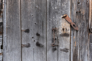 The old door locked with a padlock hanging brackets. At an angle.