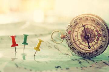 pins attached to map, showing location or travel destination and old compass.