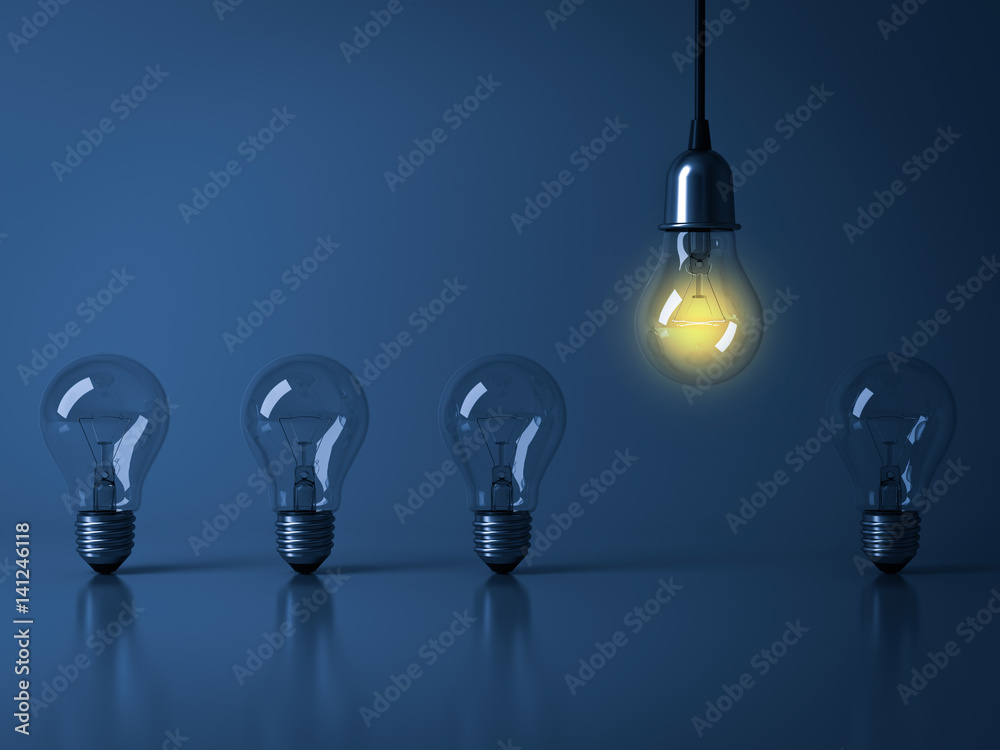 Poster one hanging light bulb glowing from unlit incandescent bulbs on dark blue background with reflection