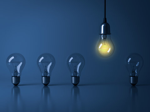 One hanging light bulb glowing from unlit incandescent bulbs on dark blue background with reflection , stand out from the crowd, leadership and different business creative idea concept . 3D rendering.