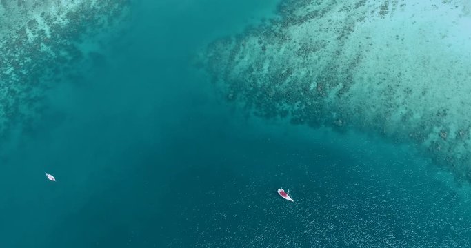 Aerial drone video of sailing boats and yachts in the bay of iconic tropical Phi Phi island, Thailand