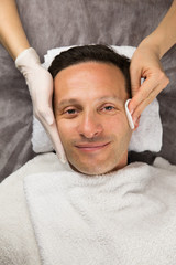 Fototapeta na wymiar Male face, hands of professional beautician with gloves