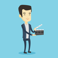 Smiling man holding an open clapperboard.