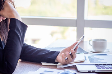 Close Up businessmen working at a coffee shop with a document with a smartphone and a laptop computer.