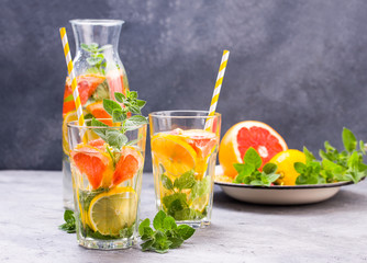 Cold refreshing summer lemonade in a glass on a grey concrete or stone background.